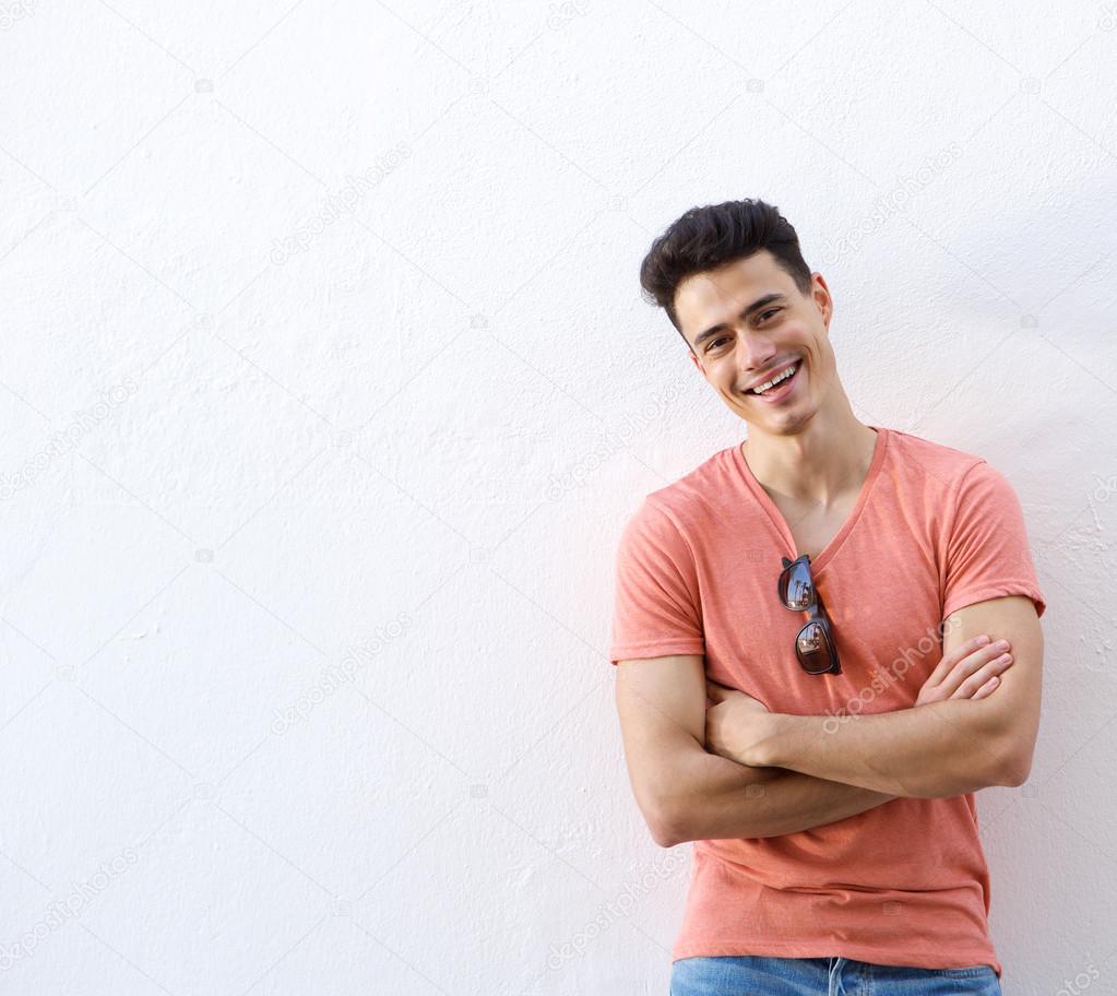Cheerful young man smiling with arms crossed 