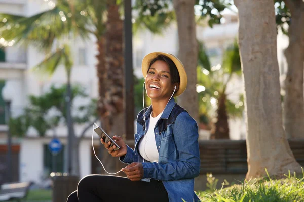 Joven mujer negra riendo con teléfono móvil — Foto de Stock