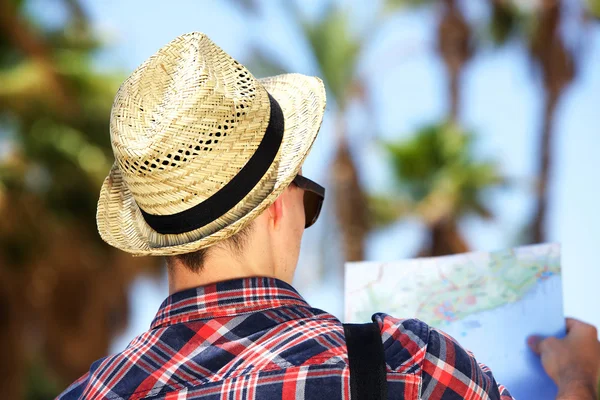 男性游客戴着帽子，看着地图上的假期 — 图库照片