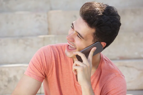 Chico alegre riendo y escuchando el teléfono celular — Foto de Stock