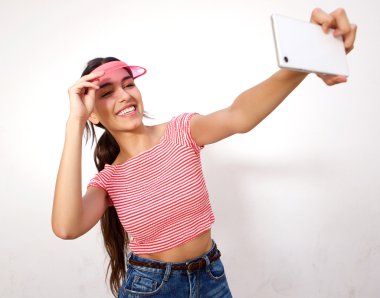 Young woman laughing and taking selfie with mobile phone