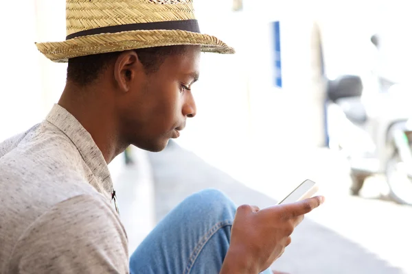 Cool black guy looking at mobile phone — Zdjęcie stockowe