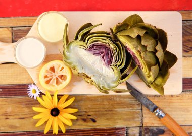 Artichoke cut in half on chopping board