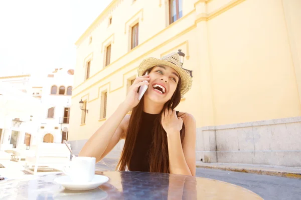 Смеющаяся молодая женщина наслаждается разговором по мобильному телефону — стоковое фото