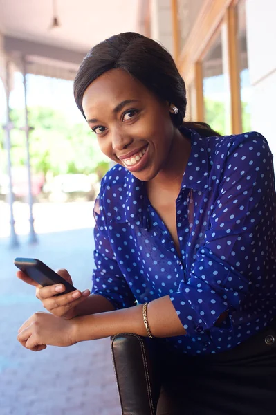 Mujer de negocios africana sonriente con teléfono celular — Foto de Stock