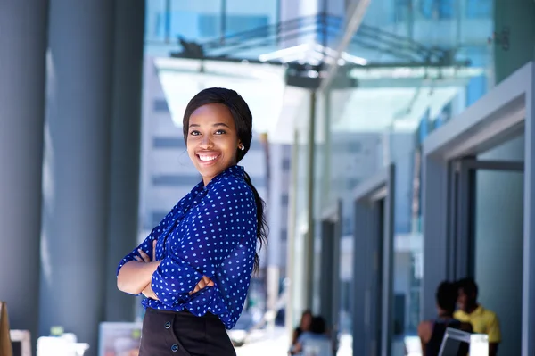 Femme d'affaires africaine souriante avec les bras croisés — Photo