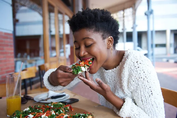 Mujer afroamericana comiendo pizza en restaurante al aire libre — Foto de Stock