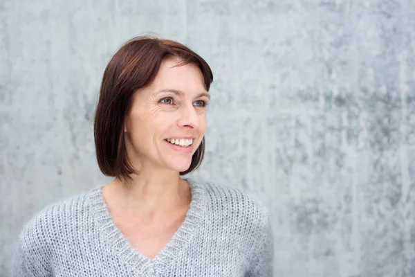 Lächelnde reife Frau im grauen Pullover — Stockfoto