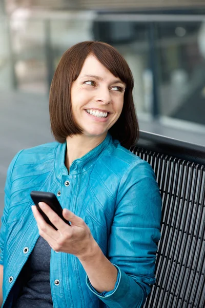 Mulher de meia idade sorrindo com telefone celular — Fotografia de Stock