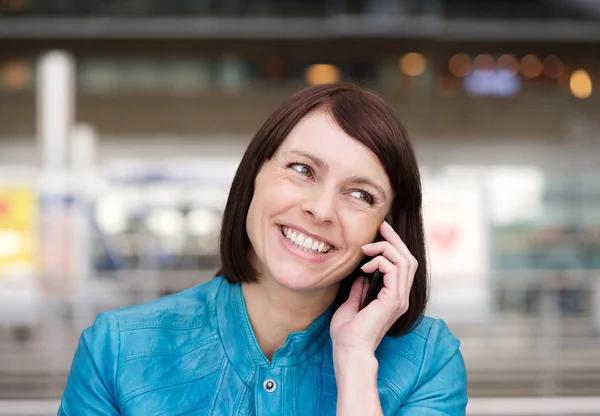 Äldre kvinna ler när talar i mobiltelefon — Stockfoto