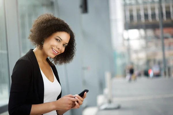 Ділова жінка посміхається з мобільним телефоном — стокове фото