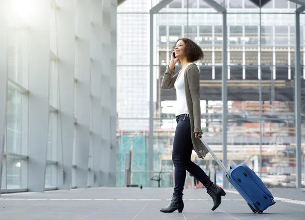 Junge Frau mit Handy und Koffer unterwegs — Stockfoto