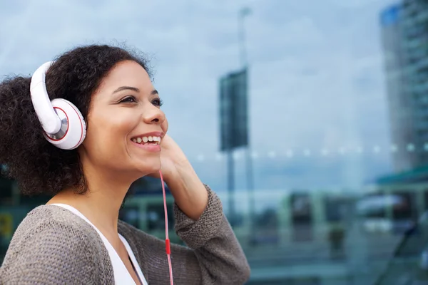 Unga afroamerikanska kvinna lyssna på musik i hörlurar — Stockfoto