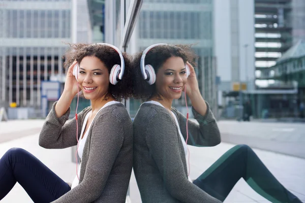 Souriant afro-américaine fille écouter de la musique sur écouteurs — Photo