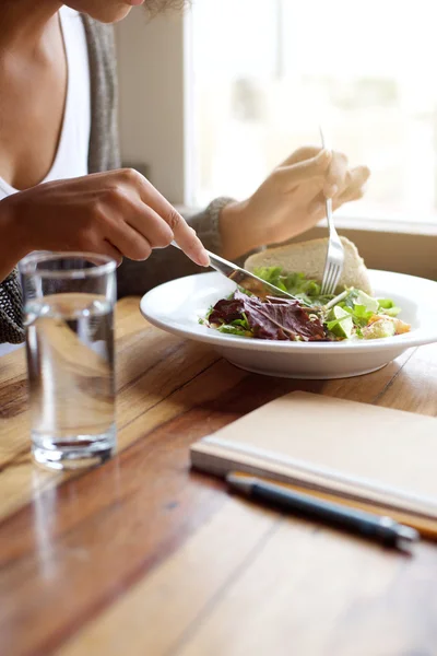 Young female eating salad at restaurant — Stock Photo, Image