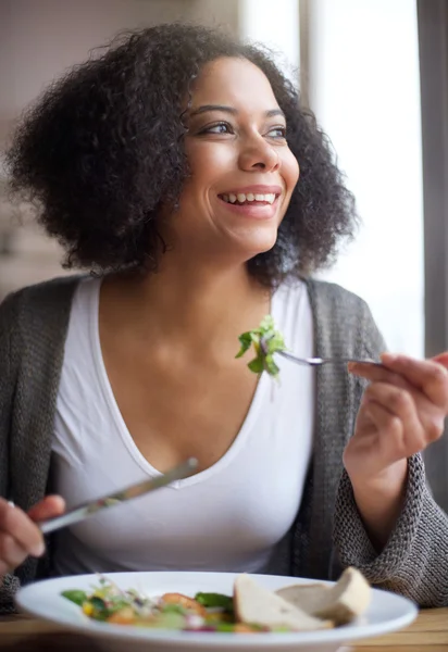 Attractive african american woman eating salad at home — Stock Photo, Image
