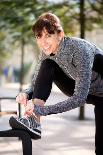 Leende sportiga kvinna kopplingsförbehåll Skosnöre utanför — Stockfoto