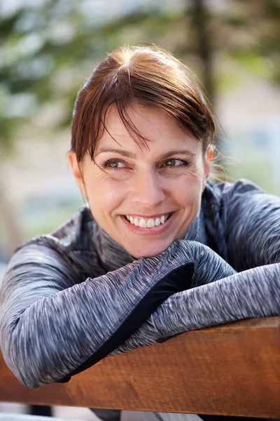 Wanita olahraga tersenyum duduk di luar — Stok Foto