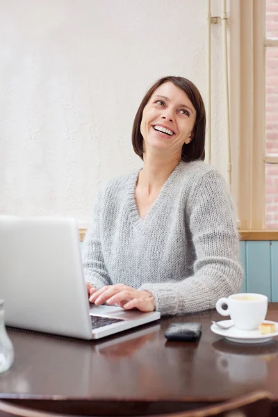 Gülümseyen yaşlı kadın evde laptop kullanma — Stok fotoğraf