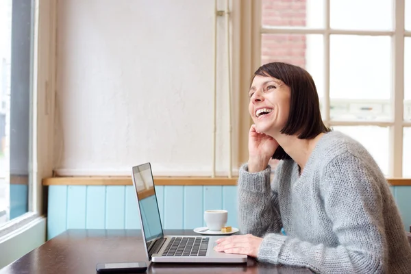 Mulher rindo com laptop em casa — Fotografia de Stock