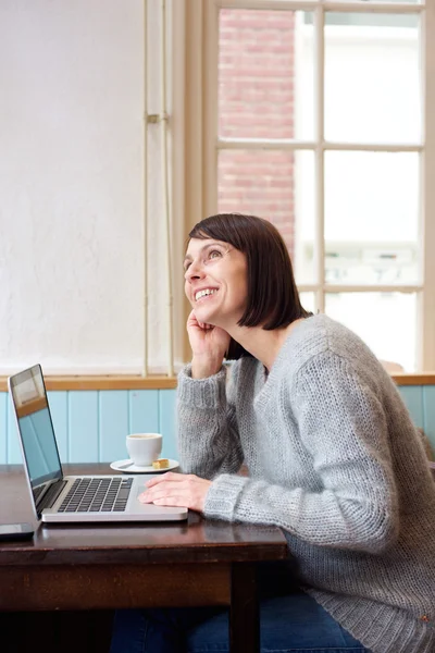 Kvinna med laptop dagdrömmer — Stockfoto