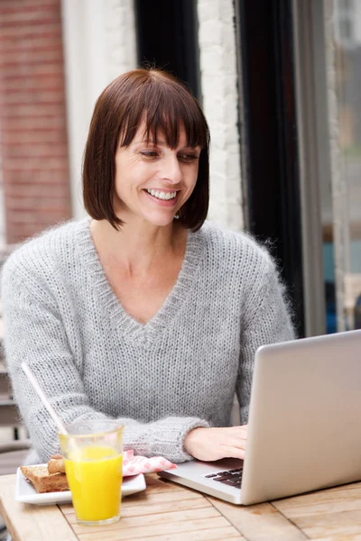 Attraktiv kvinna ler med laptop — Stockfoto