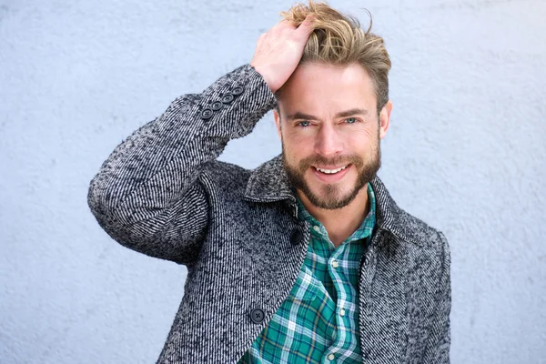 Smiling man with hand in hair — Stock Photo, Image