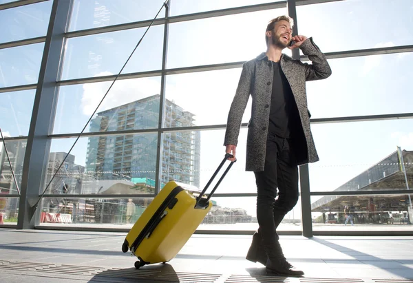 Sorrindo homem de viagem andando e falando no telefone celular — Fotografia de Stock