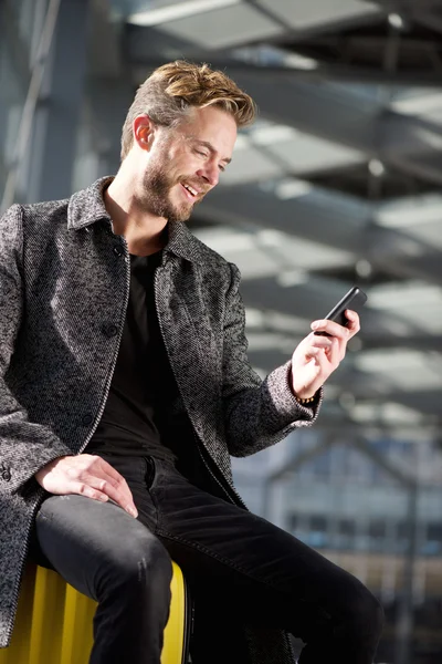 Lachende reizen man ontspannen met mobiele telefoon op luchthaven — Stockfoto