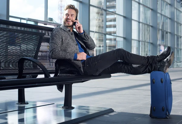 Sonriente viajero hablando por teléfono móvil en el aeropuerto — Foto de Stock