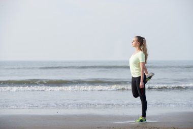 Plajda egzersiz germe sportif genç kadın