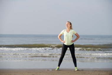 Sportif kadın plajda gülüyor