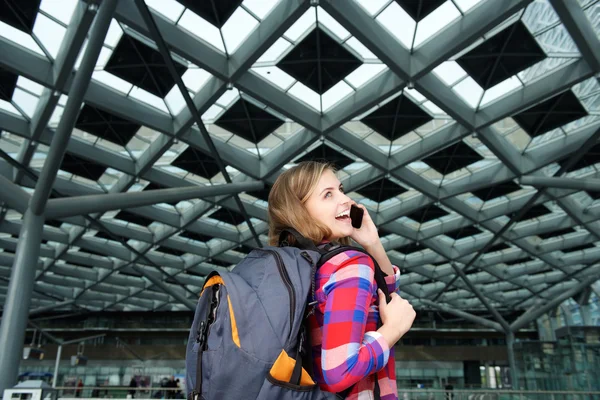 Sonriente joven viajera con mochila y teléfono móvil — Foto de Stock