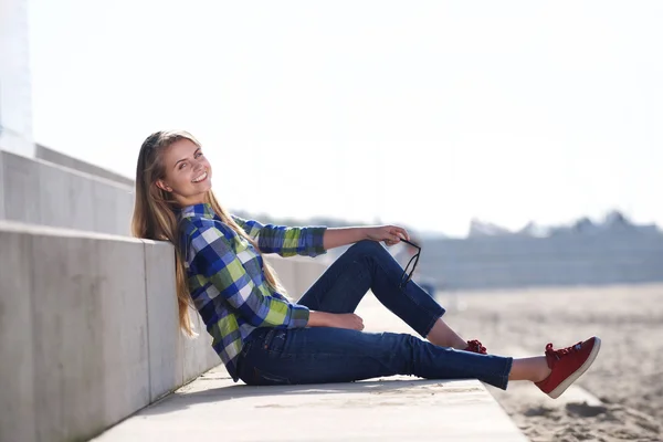 야외에서 앉아 웃는 젊은 여자 — 스톡 사진