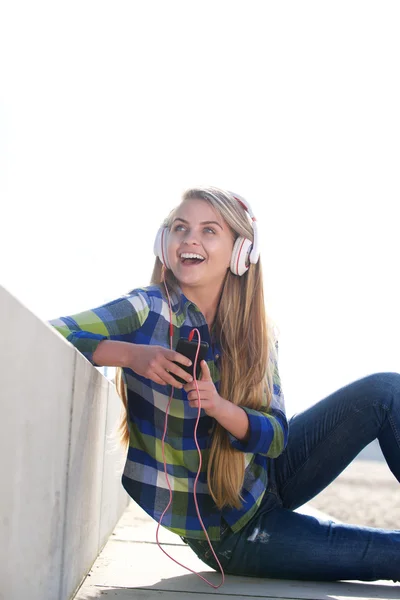 Jeune femme riant avec écouteurs et téléphone intelligent — Photo