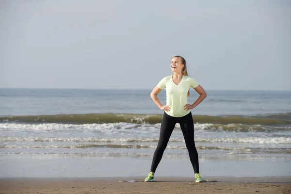 Junge sportliche Frau lacht am Strand — Stockfoto