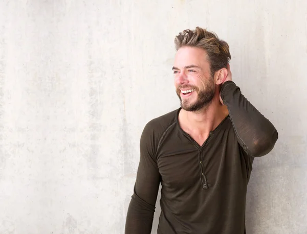 Bonito homem com barba rindo com a mão no cabelo — Fotografia de Stock