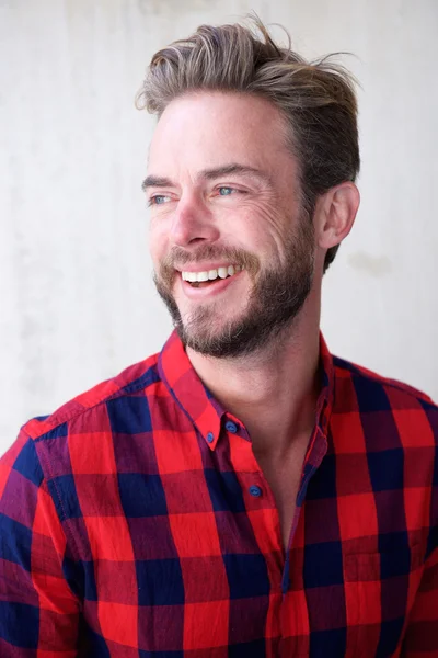 Hombre guapo con barba sonriendo y mirando hacia otro lado — Foto de Stock