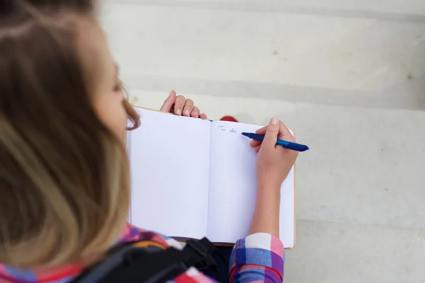 Junge Frau schreibt To-do-Liste in Buch — Stockfoto