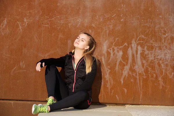 Fitnessfrau sitzt entspannt draußen — Stockfoto