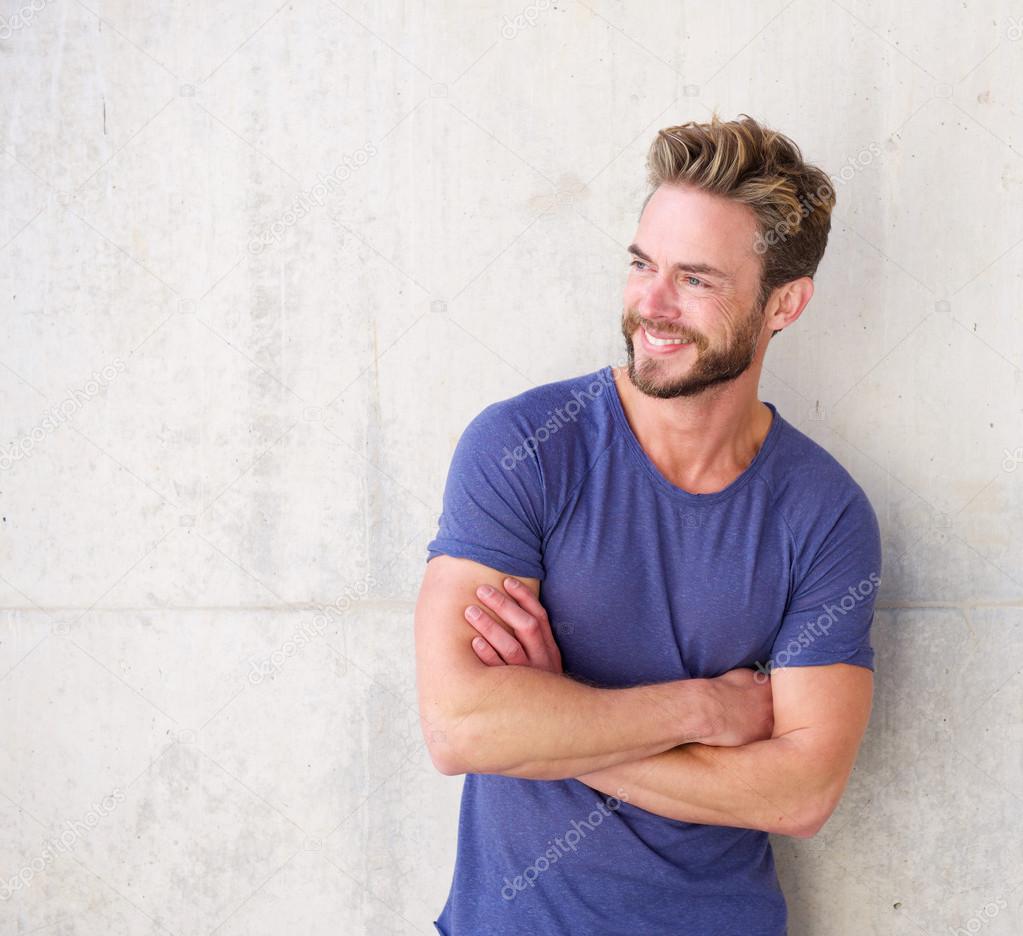 Smiling confident guy with beard posing with arms crossed