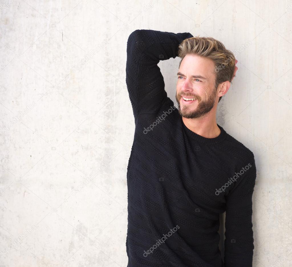 Smiling male fashion model posing in black sweater