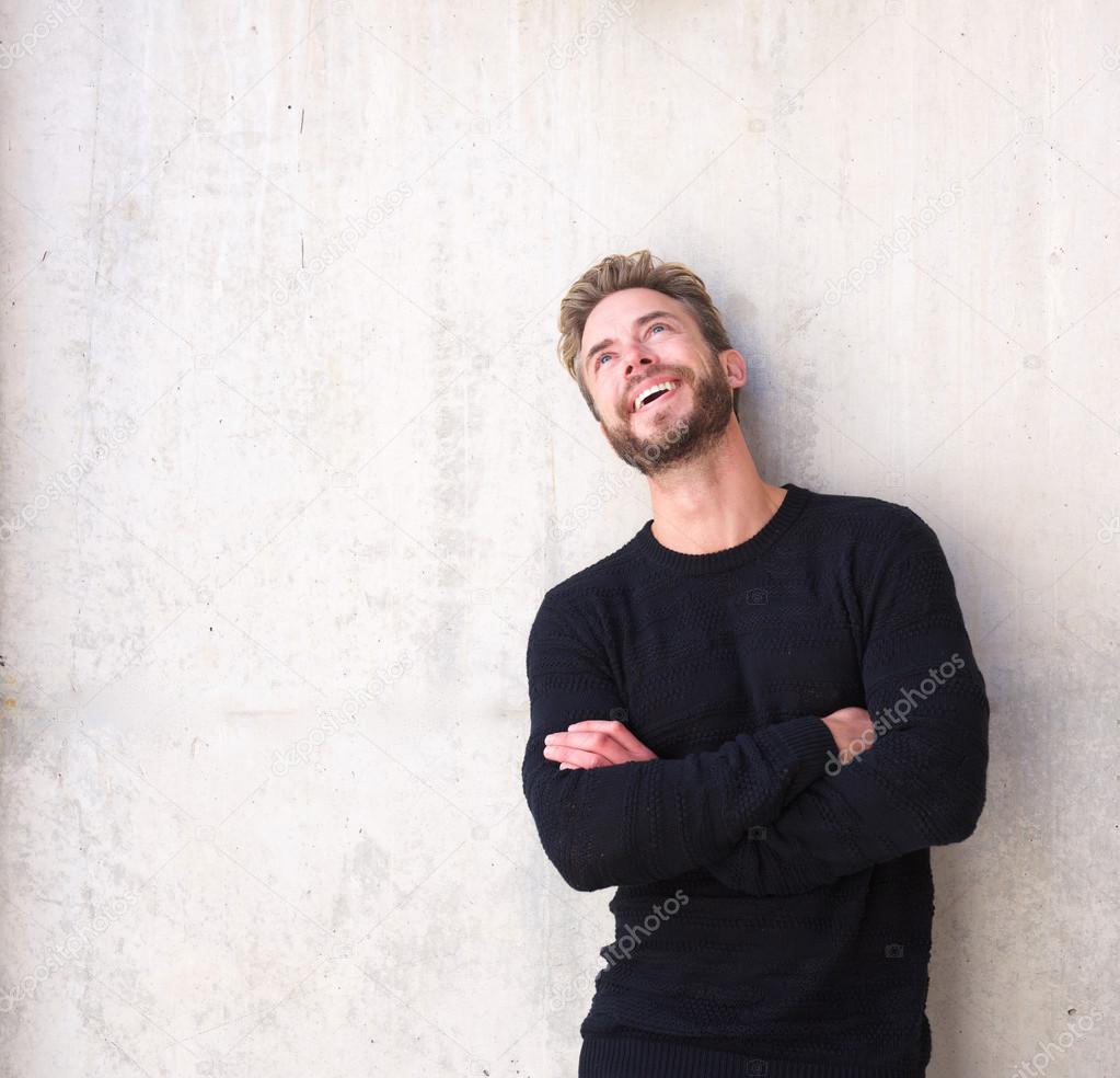 Cheerful man laughing and looking up