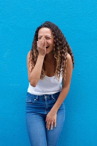 Mujer joven riendo contra la pared azul — Foto de Stock