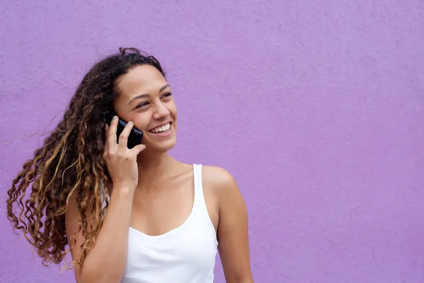 Leende kvinna talar i mobiltelefon och tittar bort — Stockfoto