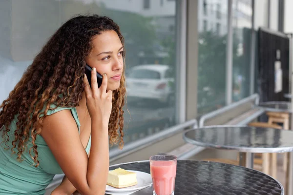 Jonge vrouw in café maken van een telefoongesprek — Stockfoto