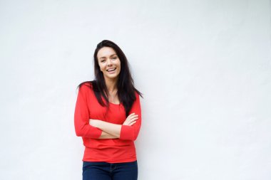 Gülümseyen genç kadın kırmızı tişörtlü beyaz arka plan üzerinde gülümseyen