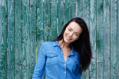 Gülümseyen mavi gömlek ile esmer kadın