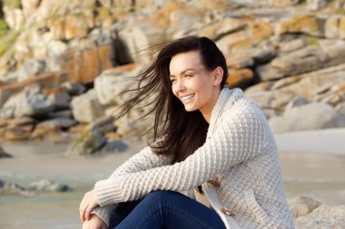 Açık havada süveterin içinde oturan Amiling kadın 