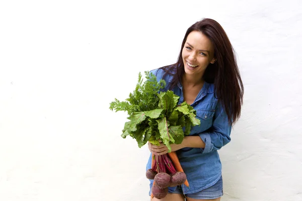 Улыбающаяся женщина с кучей овощей — стоковое фото